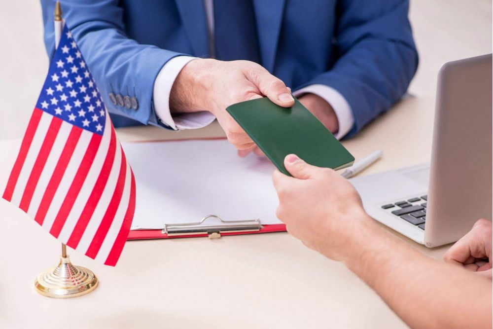 a man in a blue suit is holding a green card