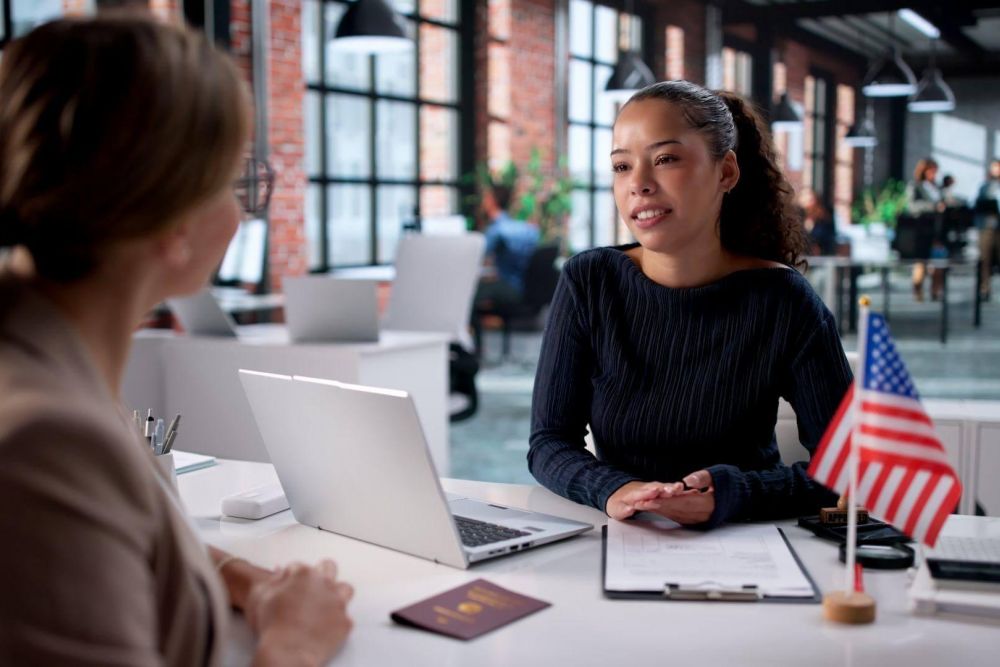 a woman sitting at a table with a laptop