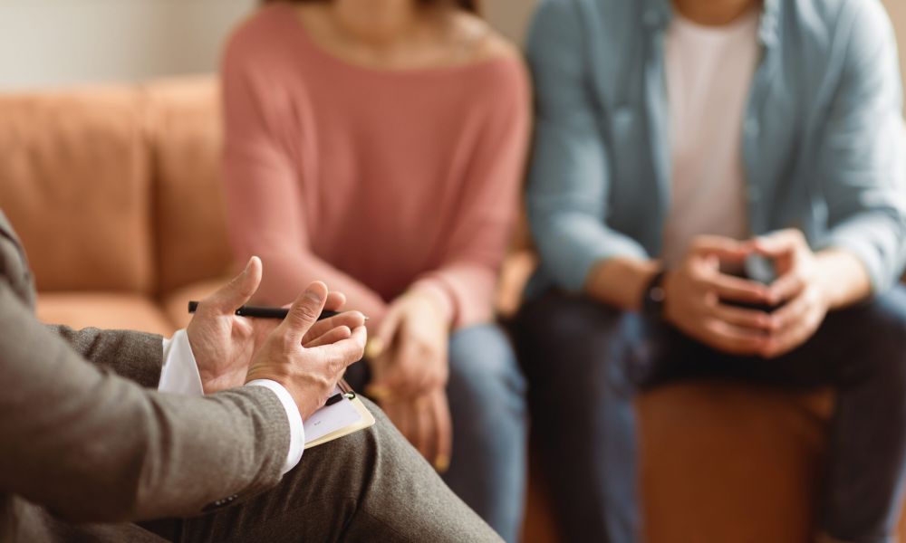 Therapist talks to a couple during a counseling session, focusing on effective communication and relationship advice.
