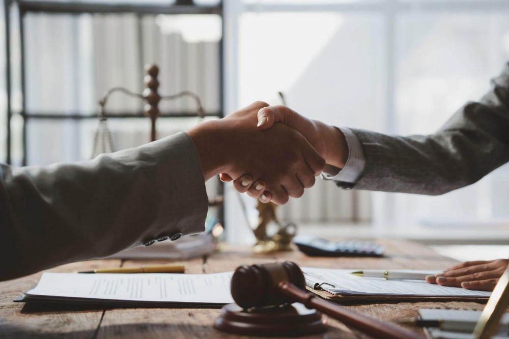 Dos personas estrechándose las manos sobre