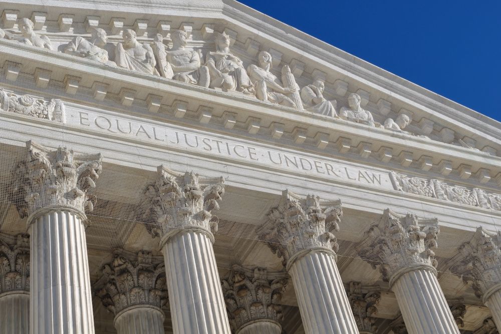Close-up of Supreme Court building facade with Equal Justice Under Law inscription and Corinthian columns.