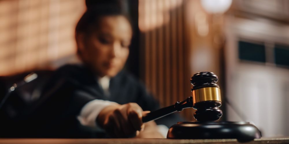 Judge using a gavel in a courtroom, symbolizing justice and legal authority.