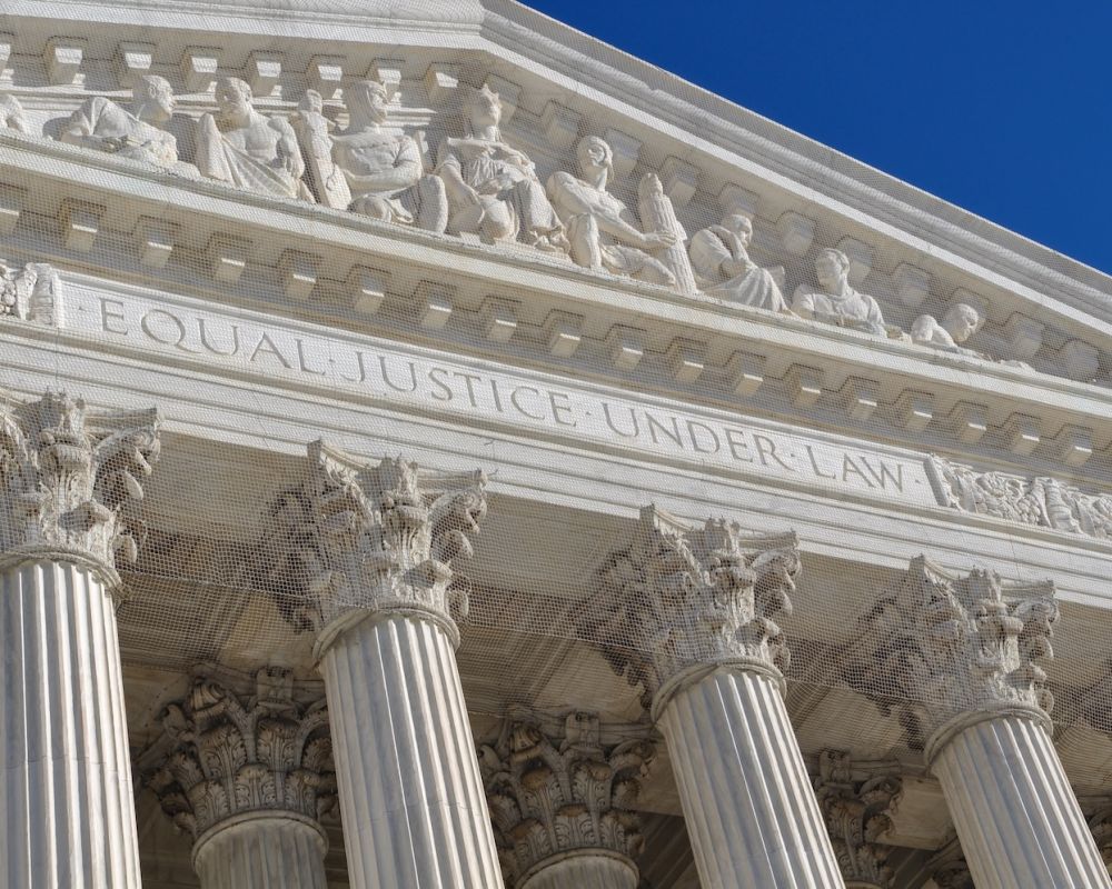 Close-up of Supreme Court building facade with Equal Justice Under Law inscription and Corinthian columns.