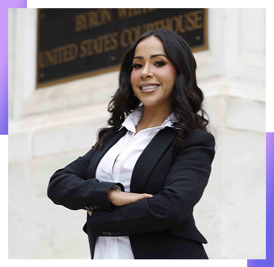 Confident professional woman in suit standing outside courthouse, smiling with crossed arms.